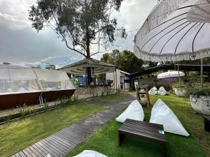 a park with tents and a bench and an umbrella at villa tibra in Lembang