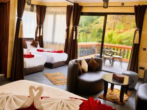 a hotel room with two beds and a balcony at Aurocher Marrakech Ourika Oukaimeden in Oukaïmeden