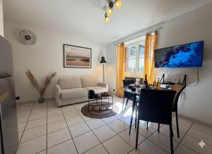 a living room with a table and a couch at Le Domi Hyper Centre Proche Cols Stations in Saint-Jean-de-Maurienne