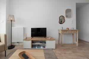 a living room with a tv and a table at La belle étoile - 4 pers - balcon in Vannes +9 photos
