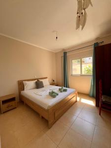 a bedroom with a bed and a window and a ceiling at Milto's Rooms in Himare