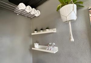 a bathroom with white shelves and a basket on the wall at villa tibra in Lembang