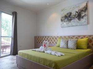 a bedroom with a bed with a bunny made out of towels at Bohol Dreamcatcher Resort in Panglao Island +45 photos