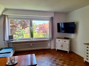 a living room with a large window and a table at Ferienwohnung Abendsonne, Winsen in Winsen
