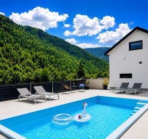 a swimming pool with a swan in the middle at HOLIDAY HOUSE - River Bača in Most na Soči