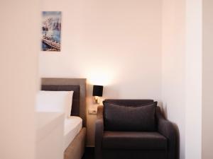 a bedroom with a bed and a chair and a picture at Hotel Keli in Ksamil