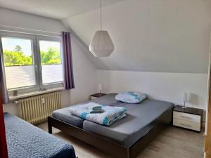 a bedroom with a bed and two windows at Ferienwohnung Abendsonne, Winsen in Winsen