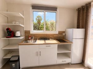 a kitchen with a white refrigerator and a window at Smart Deluxe Studio N9 private Kitchenette Balcony Beach 250m Marina Port 900m in Limassol +9 photos