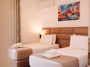 two beds in a hotel room with towels on them at Hotel Keli in Ksamil