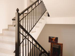 a staircase with black railings and white walls at Hotel Keli in Ksamil +26 photos