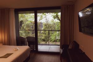 a hotel room with a bed and a large window at Huyze Fox - Boutique Stays in Bruges