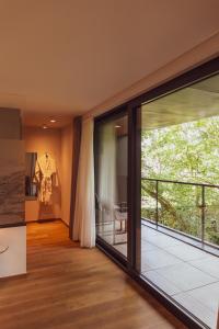 a room with sliding glass doors and a balcony at Huyze Fox - Boutique Stays in Bruges