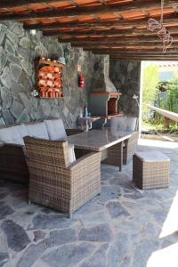 a patio with a table and chairs and a stone wall at Casa do Sol in Safara
