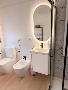 a white bathroom with a sink and a mirror at Novelli Homes in Formigine +7 photos