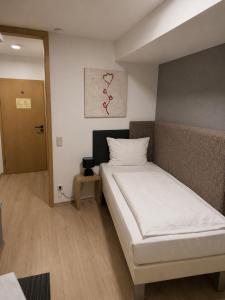 a bedroom with a white bed in a room at Hotel Eurocity in Bruchköbel