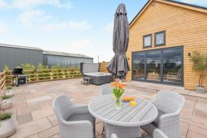 a patio with a table and chairs and an umbrella at 2 Bed in Blakeney oc-m42455 in Awre