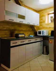 a kitchen with white cabinets and a counter top at pension U Jiřího in Ludvíkov