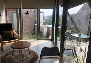 a room with chairs and tables and a large window at villa tibra in Lembang