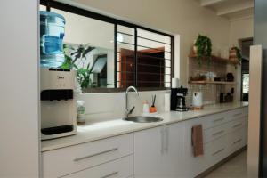 a kitchen with a sink and a counter top at SeaWaves Beach House, Shelly Beach in Shelly Beach