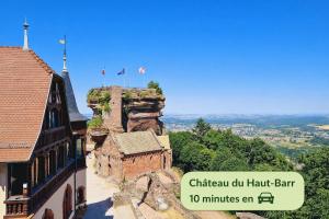 a building with flags on top of a mountain at L'Atelier de Tropique in Saverne