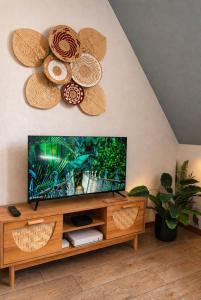 a living room with a television and a flower on the wall at L'Atelier de Tropique in Saverne