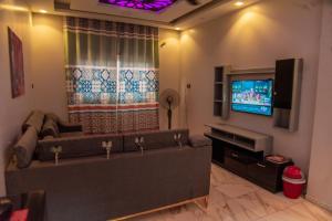 a living room with a couch and a flat screen tv at New Villa Carimo in Quseir