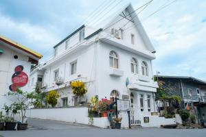 a white building with flowers in front of it at Maluda B&B in Taimali