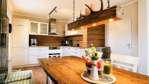 a kitchen with white cabinets and a wooden table at EulenNest - Ferienhaus in Seeboden am Millstätter See mit Bergblick & Sauna in Seeboden +33 photos