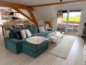 a living room with a blue couch and a table at Ferienwohnung Hintermoos in Kißlegg