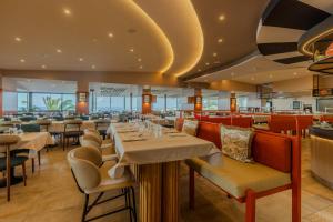 a restaurant with tables and chairs and a bar at Aldiana Club Rocca Nettuno Calabria in Tropea