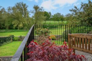 a fence with a bunch of red flowers next to a bench at 3 Bed in Coldstream oc-c39085 in Coldstream