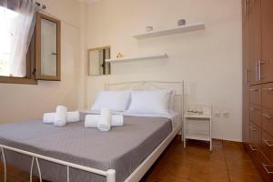a bedroom with a bed with white pillows and a mirror at Emilia's Guest House with Sea View Balcony, Stoupa in Stoupa