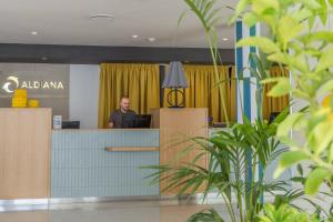 a man sitting at a reception desk in an office at Aldiana Club Rocca Nettuno Calabria in Tropea +34 photos