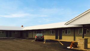 a building with a car parked in a parking lot at Relax Inn Bloomsburg in Bloomsburg