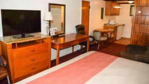 a hotel room with a bed and a desk with a television at Relax Inn Bloomsburg in Bloomsburg +12 photos