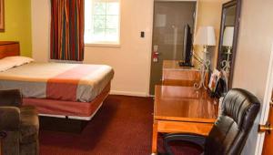 a bedroom with a bed and a desk and a sink at Relax Inn Bloomsburg in Bloomsburg