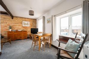 a living room with a table and chairs and a television at 2 Bed in Thurleigh oc-o42689 in Thurleigh