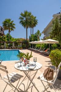 a patio with a table and chairs next to a pool at WEST HOUSE EXCLUSIVE HOTEL in Göcek
