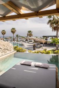 a swimming pool with two pillows on a patio at Blue Carpet Luxury Suites in Pefkochori