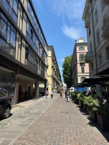 a street with buildings and people walking down a sidewalk at Centro - doppia in casa d'artista in Turin