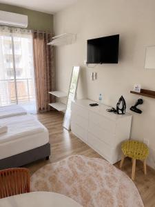 a bedroom with a bed and a tv on the wall at Smart Deluxe Studio N9 private Kitchenette Balcony Beach 250m Marina Port 900m in Limassol