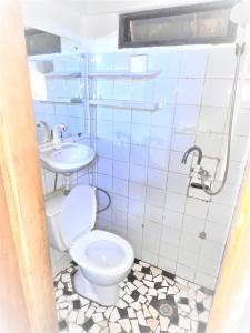 a bathroom with a toilet and a sink at The Yafé Bastos 5 in Yaoundé +5 photos