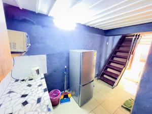 a kitchen with a refrigerator and stairs in it at The Yafé Bastos 5 in Yaoundé