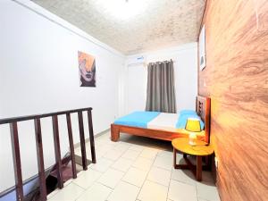 a small bedroom with a bed and a table at The Yafé Bastos 5 in Yaoundé