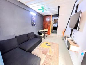 a living room with a couch and a tv at The Yafé Bastos 5 in Yaoundé