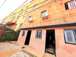 a pink building with two doors and a building at The Yafé Bastos 5 in Yaoundé