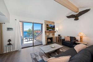 a living room with a couch and a fireplace at Village Lakefront Paradise in Lake Arrowhead