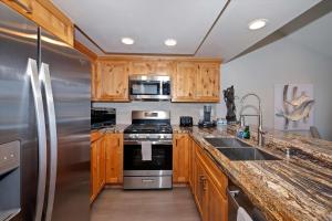 a kitchen with wooden cabinets and stainless steel appliances at Village Lakefront Paradise in Lake Arrowhead