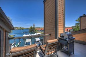 a grill on a balcony with a view of a river at Village Lakefront Paradise in Lake Arrowhead