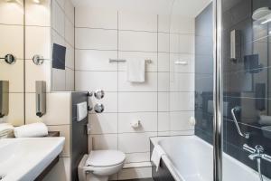 a bathroom with a toilet and a sink and a shower at PLAZA Residence Mannheim in Mannheim